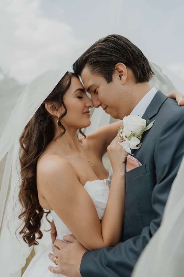 A man and a woman are kissing under a white canopy.